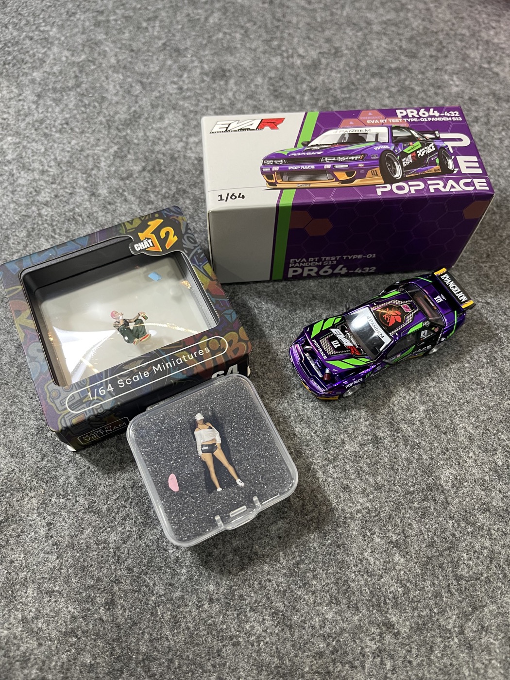 Model car, packaging, and miniature figures arranged on a desk